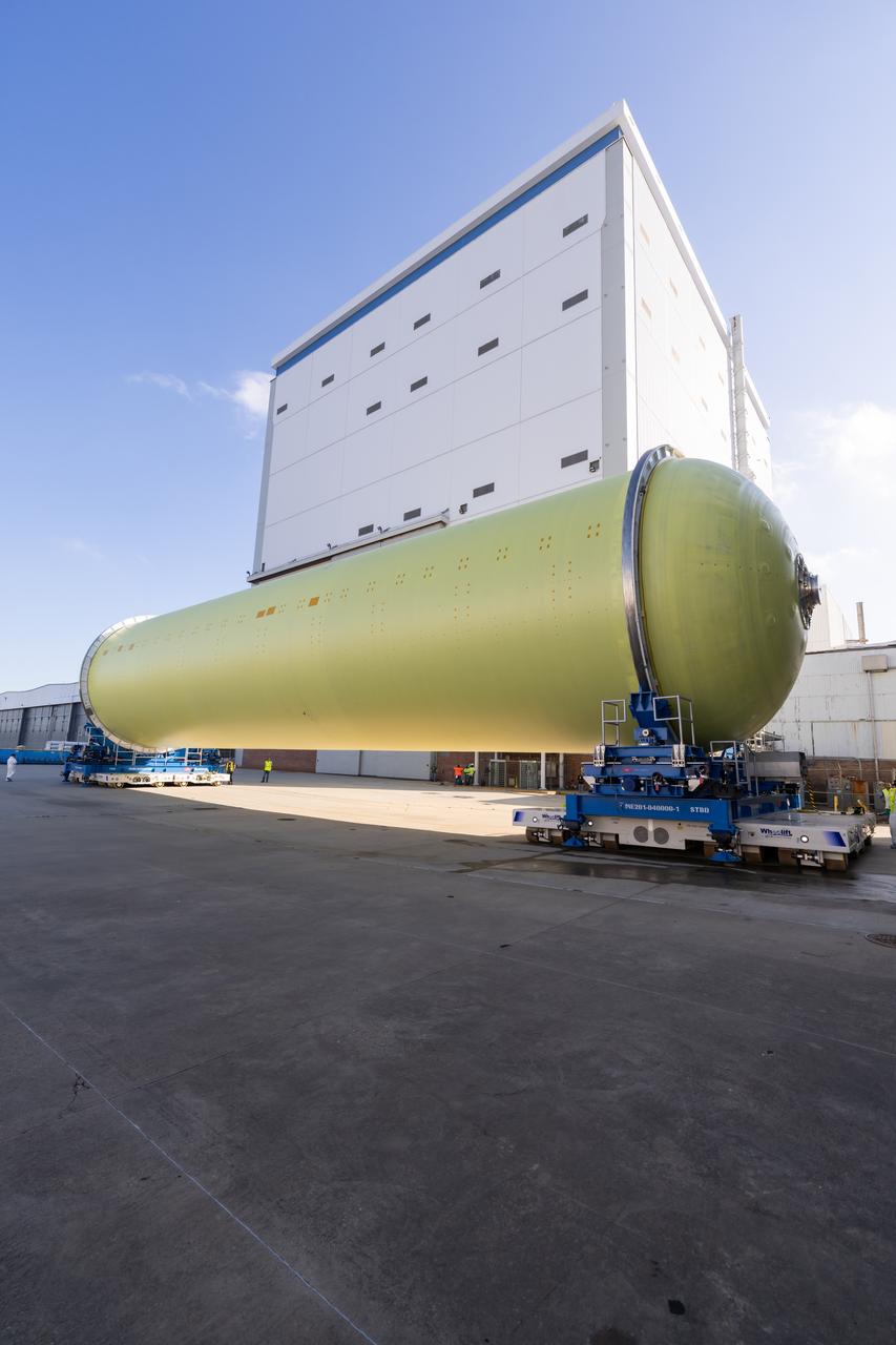 Teams move a liquid hydrogen tank for NASA’s SLS (Space Launch System) rocket out of a priming cell and into an adjacent cell on May 20 at the agency’s Michoud Assembly Facility in New Orleans. Inside the cell, the tank, which will be used on the core stage of NASA’s Artemis III mission, will receive its thermal protection system.  The thermal protection system, or spray-on foam insulation, provides protection to the core stage during launch. It is flexible enough to move with the rocket yet can withstand the aerodynamic pressures as the SLS accelerates from 0 to 17,500 mph and soars to more than 100 miles above the Earth. This third-generation insulation is more environmentally friendly and keeps the cryogenic propellant, which powers the rocket’s four RS-25 engines, extremely cold (the liquid hydrogen must remain at minus 423 degrees Fahrenheit/253 degrees Celsius) to remain in its liquid state. When applied the thermal protection system is a light-yellow color, which “tans” once exposed to the Sun’s ultraviolet rays, giving the SLS core stage its signature orange color.
